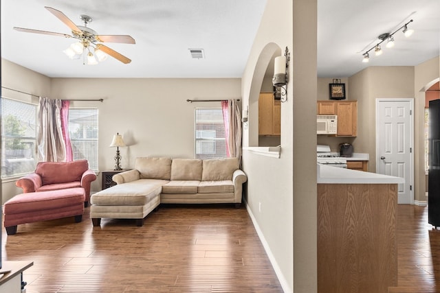 living room featuring ceiling fan and dark hardwood / wood-style floors