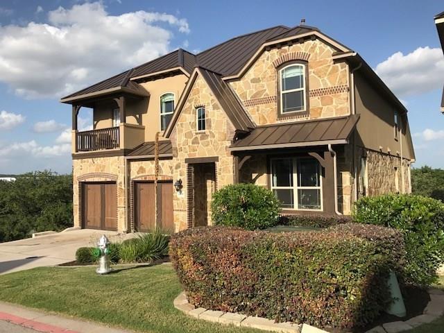 4309 Vista Verde Dr, Austin, TX 78732 - view of front of house featuring a garage, a balcony, stone siding, a standing seam roof, and concrete driveway
