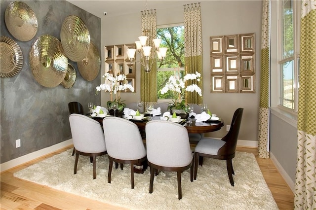 dining area featuring light wood-type flooring and a chandelier