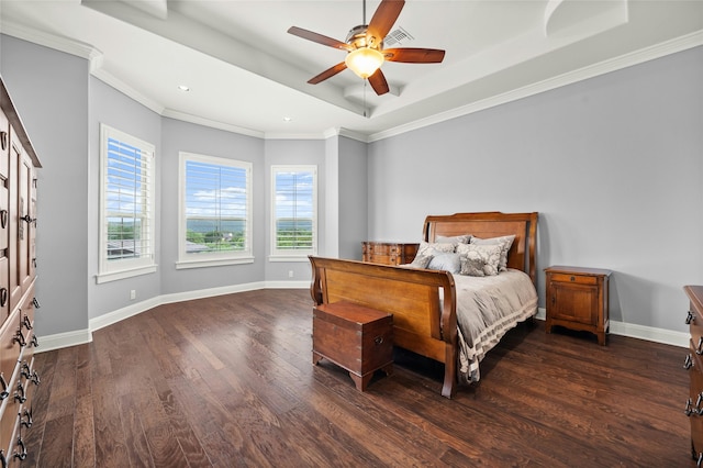 bedroom with ceiling fan, dark wood-type flooring, a tray ceiling, and ornamental molding