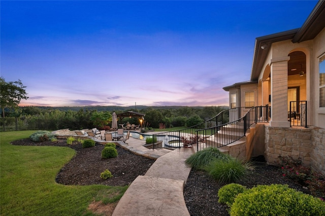 yard at dusk featuring a patio area and a gazebo