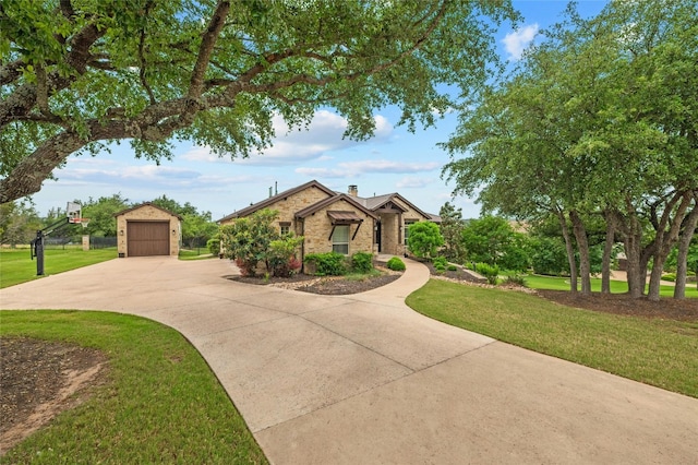 view of front of house featuring a front lawn, a garage, and an outbuilding