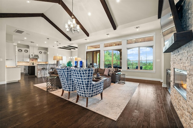 living room with beamed ceiling, a stone fireplace, high vaulted ceiling, dark hardwood / wood-style flooring, and a chandelier