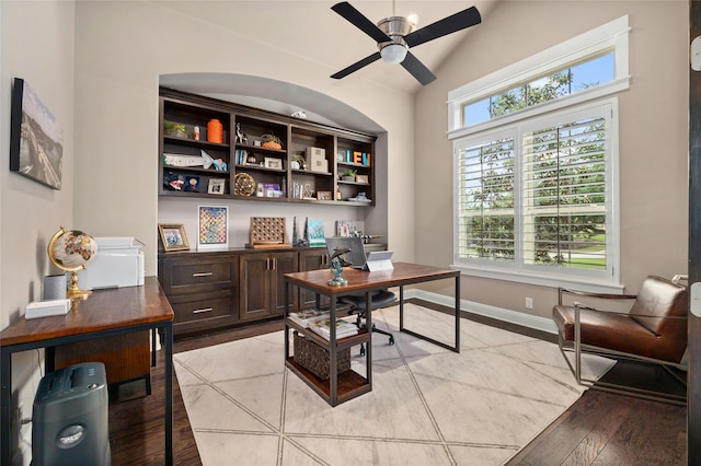 home office featuring ceiling fan, light hardwood / wood-style flooring, and vaulted ceiling