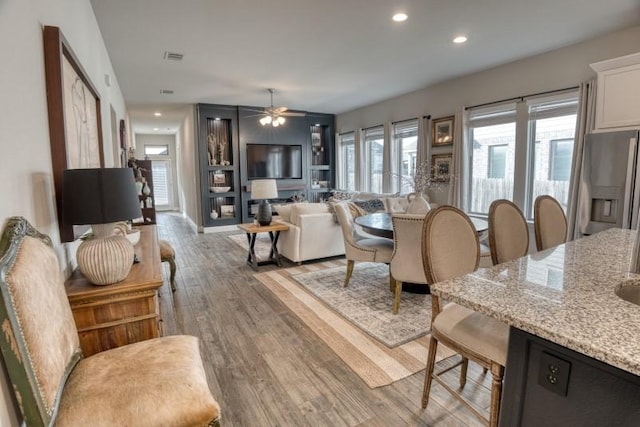 living room featuring ceiling fan and light hardwood / wood-style floors