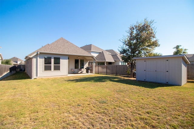 back of property featuring a yard, a patio area, and a storage shed