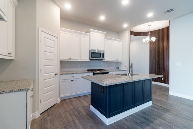 kitchen featuring sink, white cabinetry, an island with sink, stainless steel appliances, and light stone countertops