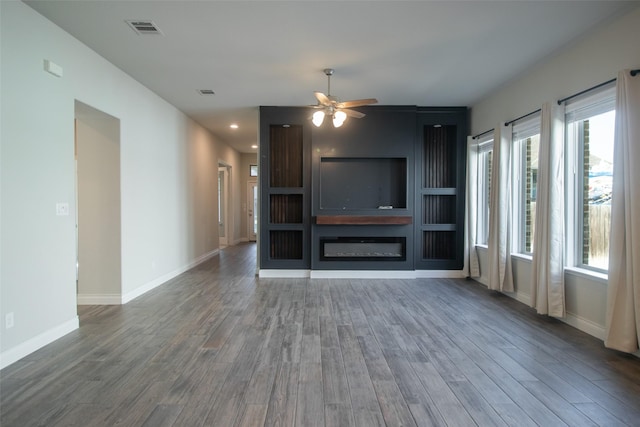 unfurnished living room with ceiling fan and dark hardwood / wood-style flooring