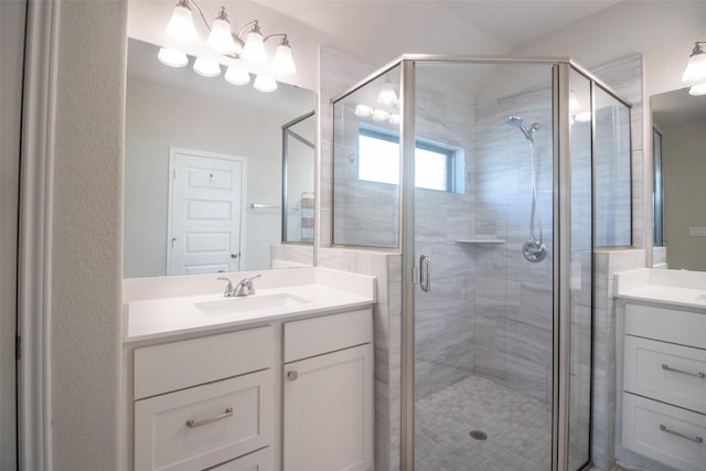 bathroom with vanity and a shower with door