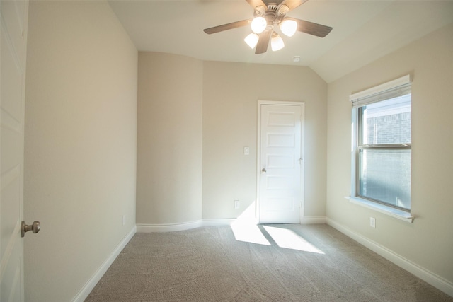 carpeted empty room with vaulted ceiling and ceiling fan