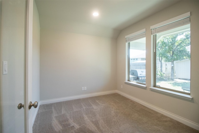 spare room featuring lofted ceiling and carpet