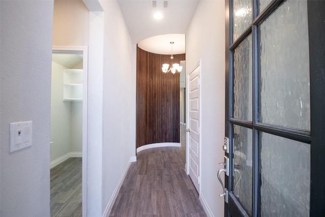 corridor featuring a notable chandelier and dark hardwood / wood-style floors