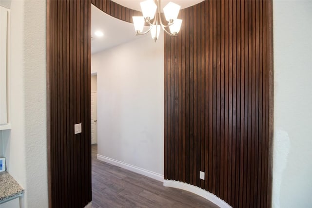 hallway featuring a notable chandelier and dark hardwood / wood-style floors