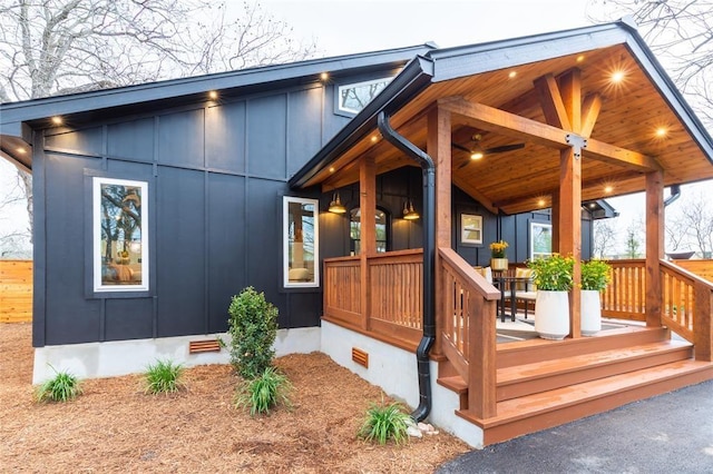 doorway to property with crawl space, board and batten siding, and a porch