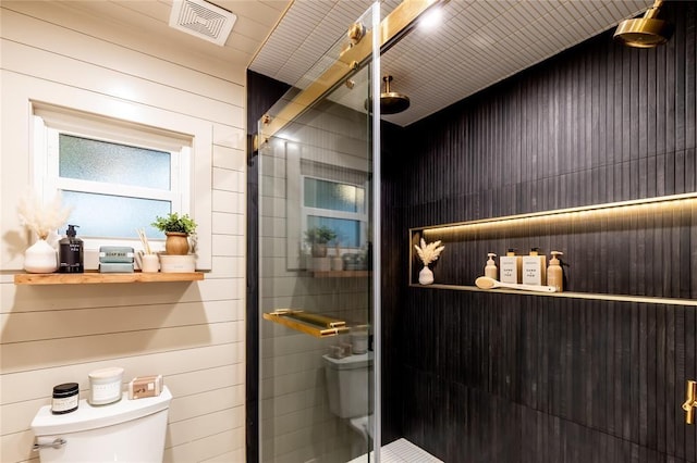 bathroom featuring toilet and a tile shower