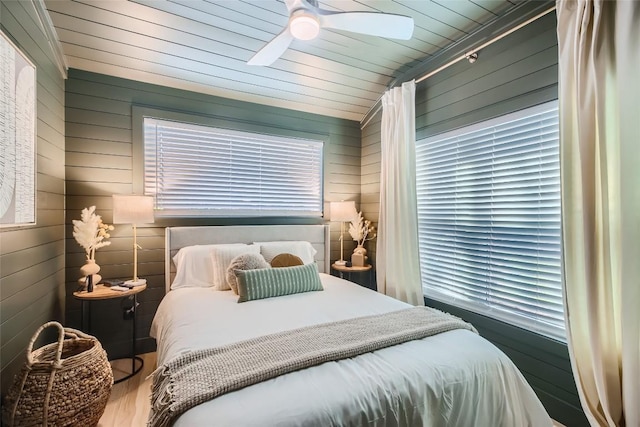 bedroom with wood walls, vaulted ceiling, wooden ceiling, wood finished floors, and a ceiling fan