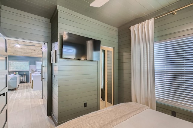 bedroom with wooden walls, wood ceiling, and wood finished floors