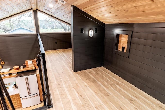 bonus room featuring vaulted ceiling, wood ceiling, wooden walls, and wood finished floors