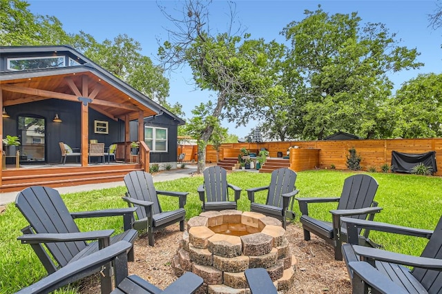 exterior space featuring a deck, a fire pit, and fence