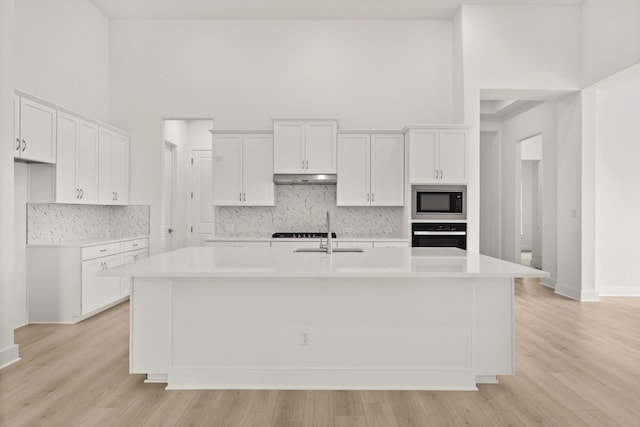 kitchen featuring white cabinets, built in microwave, and a high ceiling