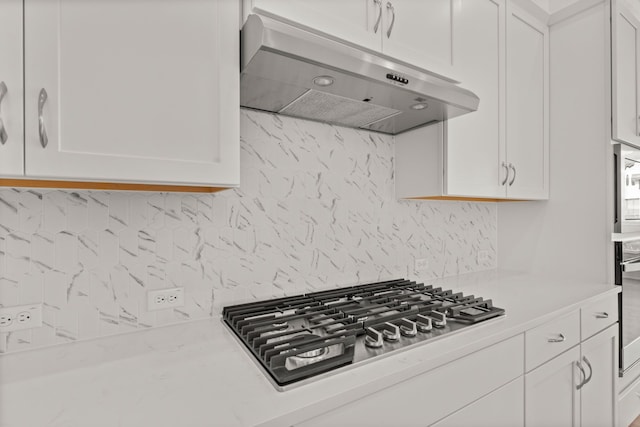 kitchen featuring white cabinets, stainless steel appliances, and tasteful backsplash