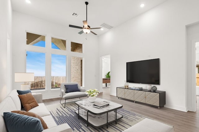 204 Camille St, Leander, TX 78641 - living room featuring wood finished floors, a ceiling fan, recessed lighting, a towering ceiling, and baseboards