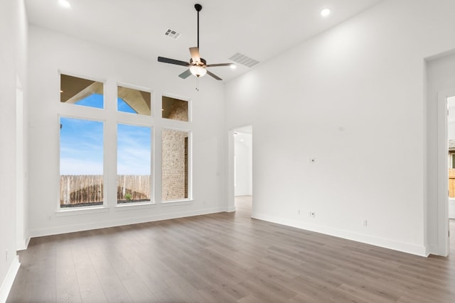 204 Camille St, Leander, TX 78641 - empty room with baseboards, ceiling fan, wood finished floors, recessed lighting, and a towering ceiling