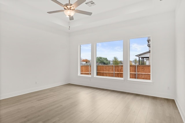 204 Camille St, Leander, TX 78641 - unfurnished room featuring light wood-style flooring, a ceiling fan, a tray ceiling, and baseboards