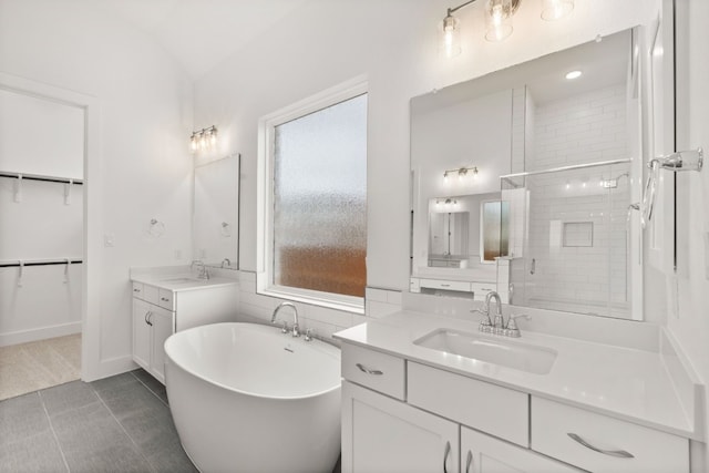 bathroom with separate shower and tub, vanity, tile patterned flooring, and vaulted ceiling