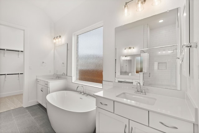 204 Camille St, Leander, TX 78641 - full bath featuring two vanities, a freestanding bath, a shower stall, tile patterned flooring, and vaulted ceiling