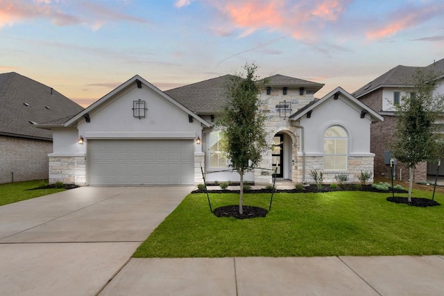 view of front of home with a garage and a yard