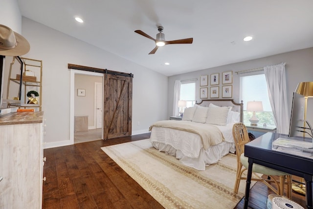 bedroom with dark wood-type flooring, lofted ceiling, a barn door, and ceiling fan