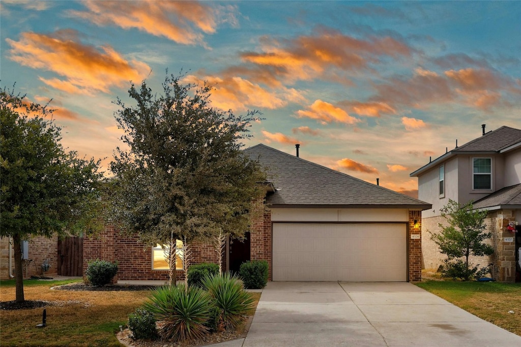 view of front of home featuring a garage and a lawn