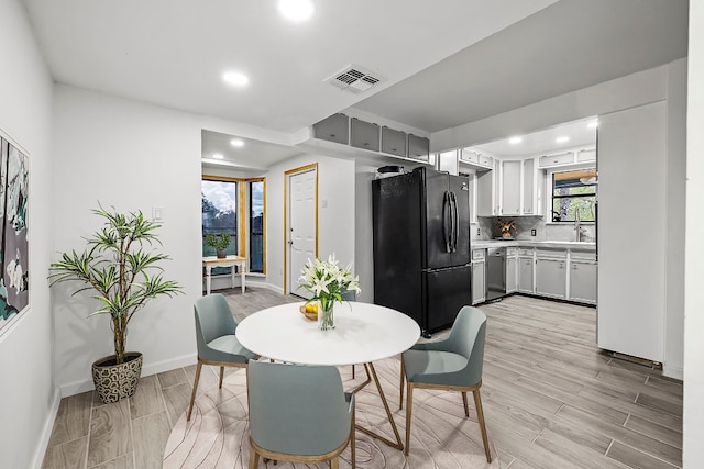 dining room with sink and light hardwood / wood-style flooring