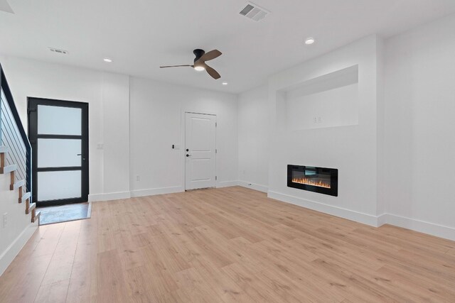 unfurnished living room featuring ceiling fan and light hardwood / wood-style flooring