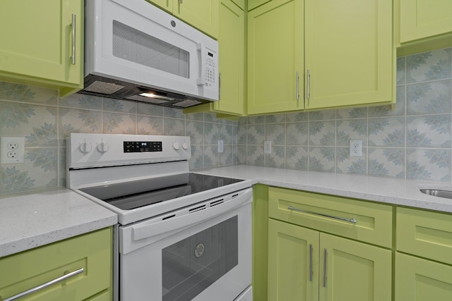 kitchen with light stone countertops, backsplash, and white appliances