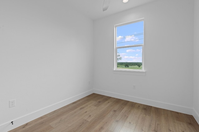 empty room with light wood-style floors, ceiling fan, and baseboards