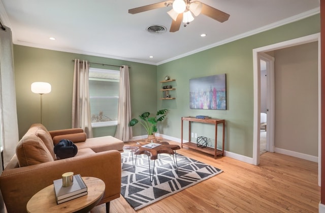 living room featuring ceiling fan, crown molding, and light hardwood / wood-style flooring