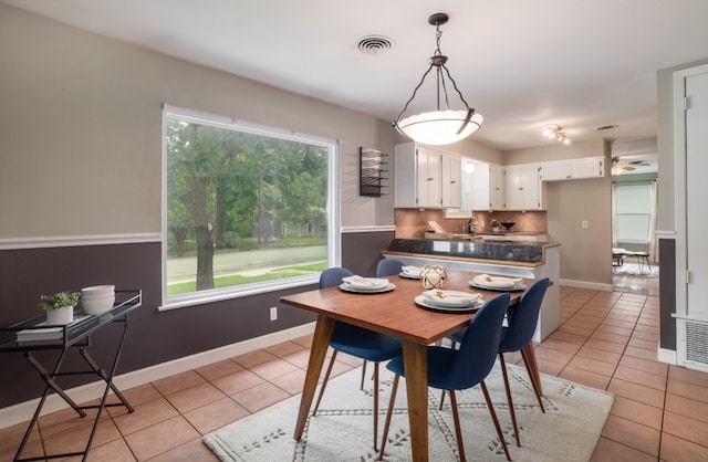 1511 Fairfield Dr, Austin, TX 78757 - dining room featuring light tile patterned floors, ceiling fan, and baseboards