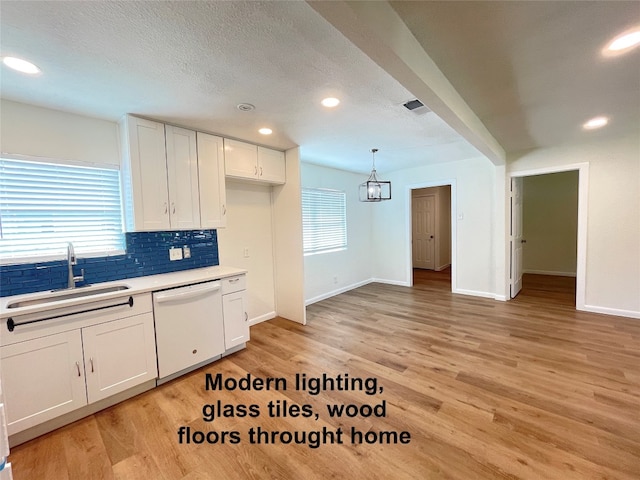 kitchen featuring light hardwood / wood-style floors, white cabinetry, sink, pendant lighting, and dishwasher