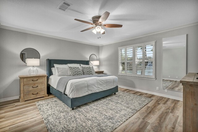 bedroom featuring crown molding, wood-type flooring, and ceiling fan