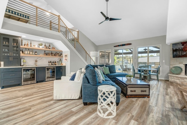 living room featuring high vaulted ceiling, wine cooler, and bar area