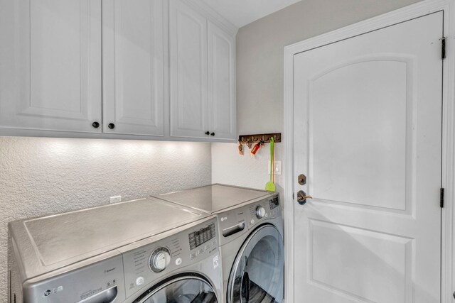 clothes washing area featuring cabinets and separate washer and dryer