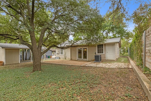 back of property with central AC unit and a patio