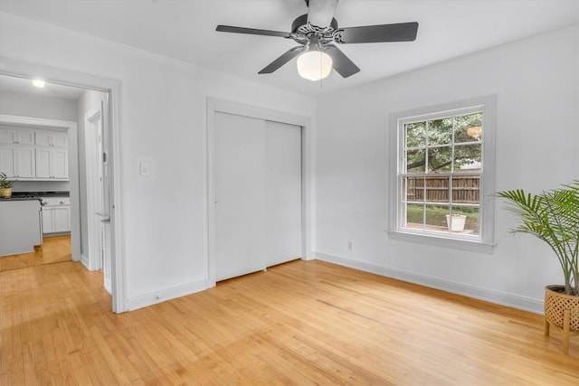 unfurnished bedroom featuring light hardwood / wood-style flooring, ceiling fan, and a closet