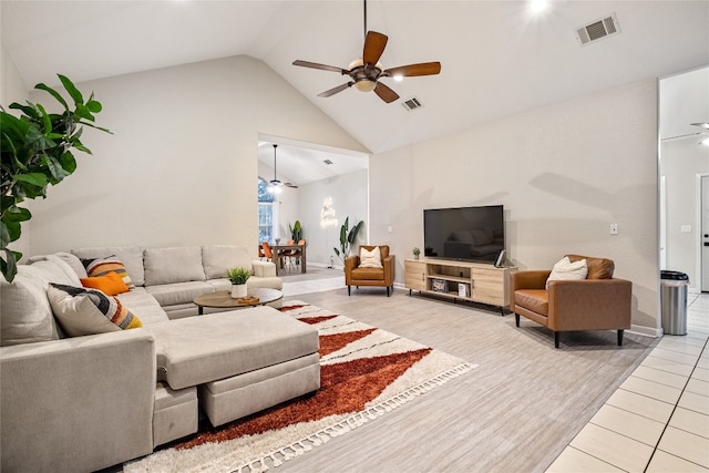 living room featuring lofted ceiling, ceiling fan, and light tile patterned floors