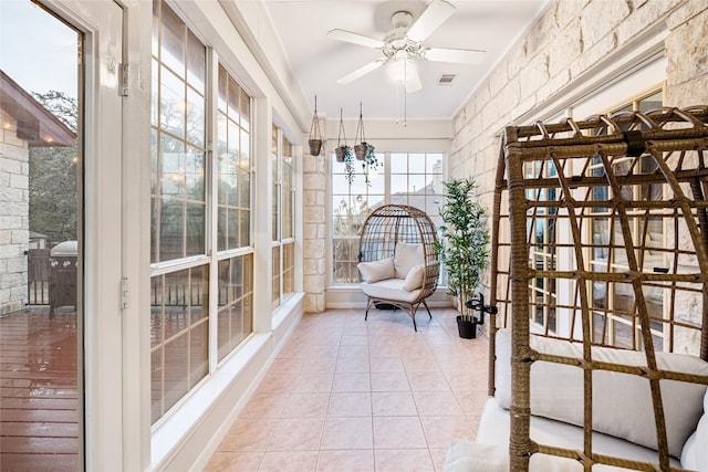 unfurnished sunroom featuring ceiling fan