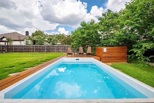 view of swimming pool with a lawn