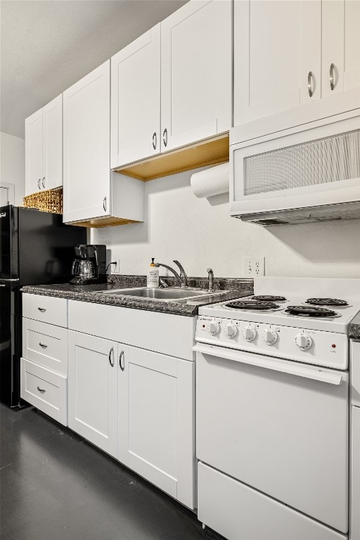 kitchen featuring white range with gas stovetop, white cabinets, sink, black fridge, and exhaust hood