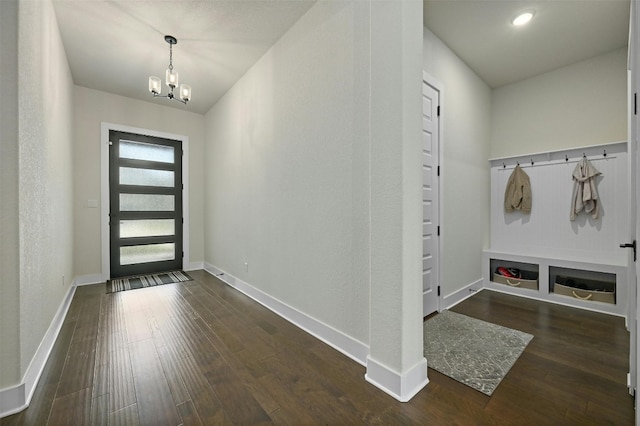 entryway with dark hardwood / wood-style floors and an inviting chandelier